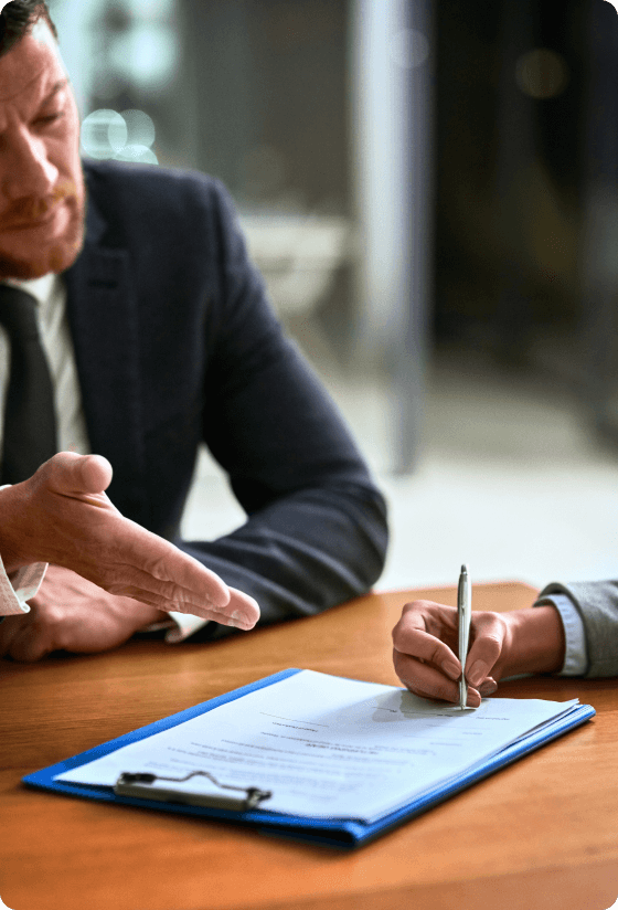 one dapper individual advising, another signing a document